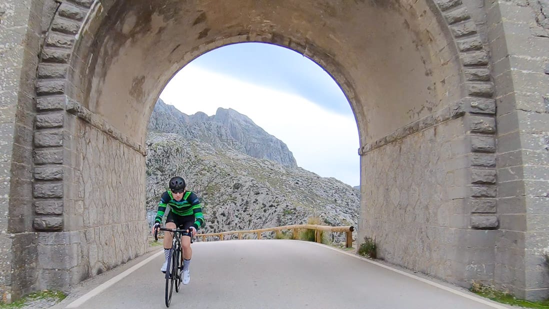 Cyclist coming through arch on Mallorca's iconic Sa Calobra climb