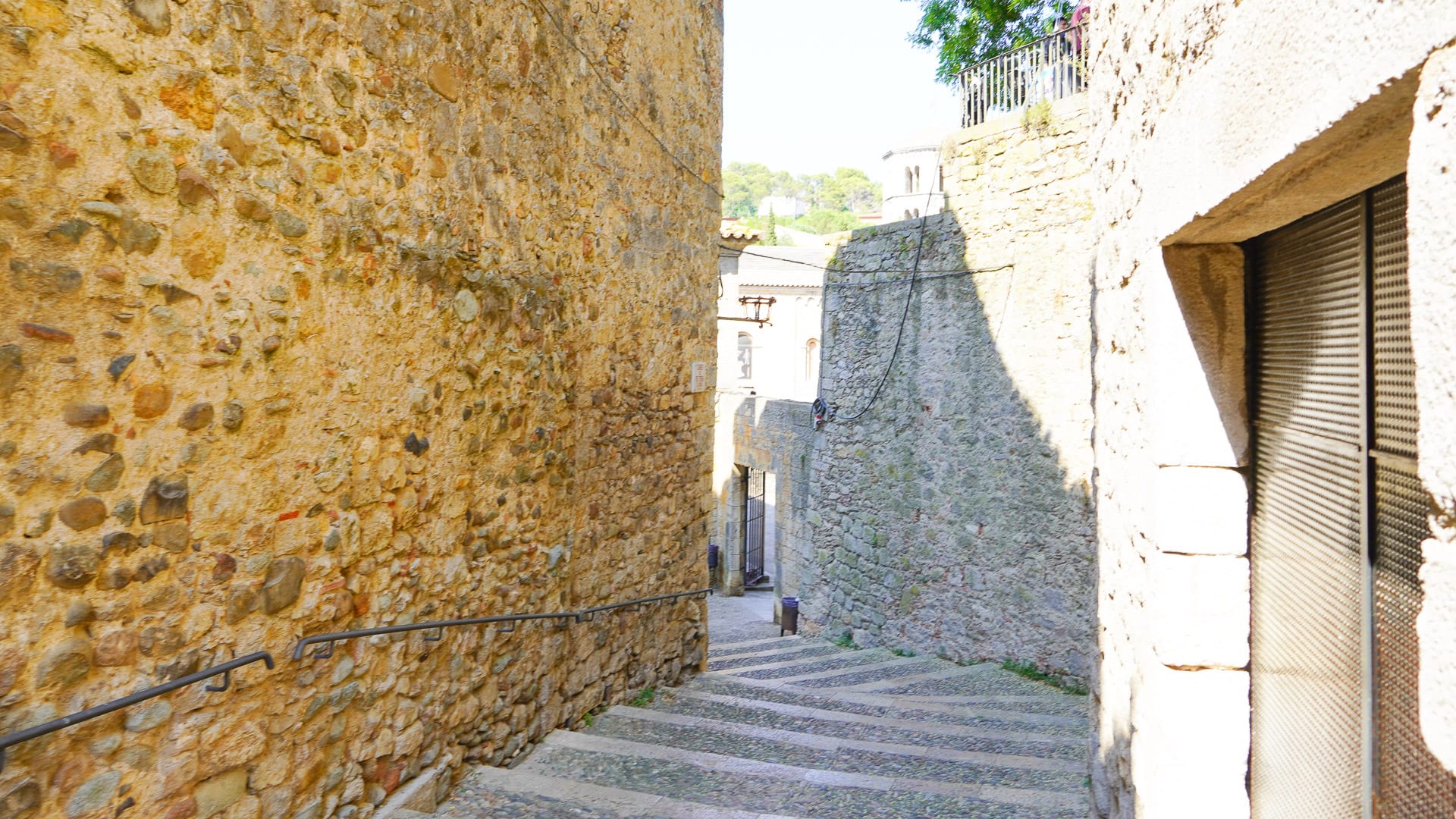 Stone stairway descending between medieval walls in Girona’s old town