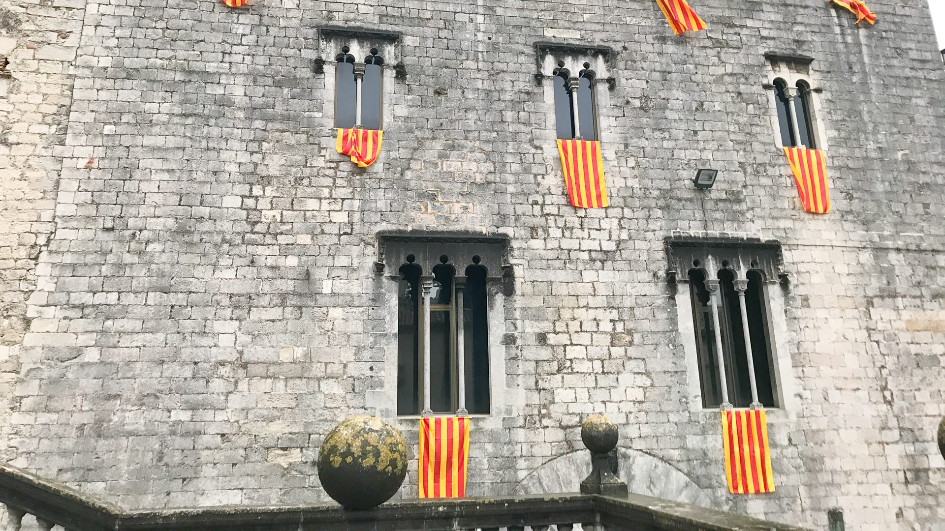 Historic building in Girona decorated with Catalan flags on windows and balconies