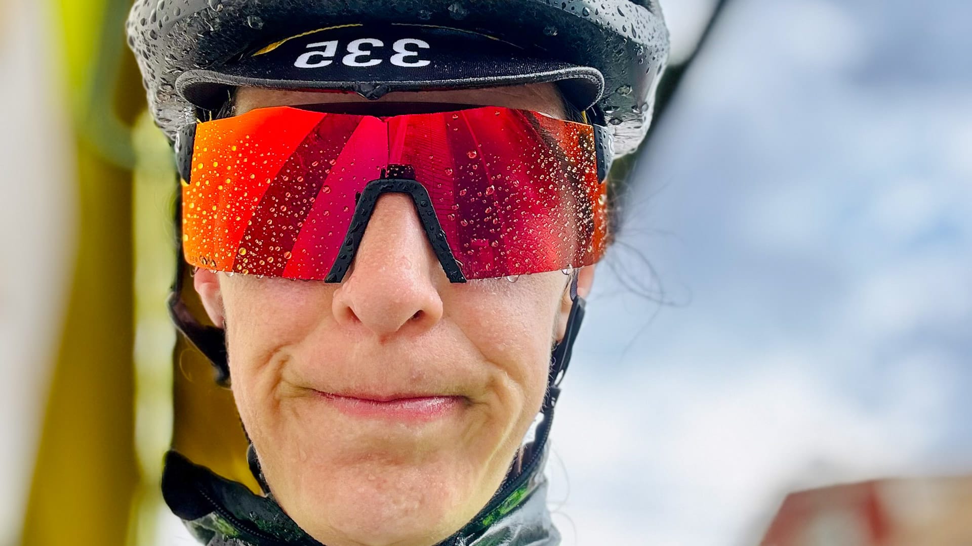 Cyclist wearing red reflective sunglasses with raindrops after a wet ride