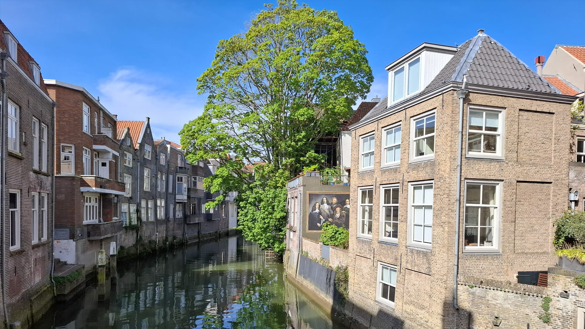 Canal lined with historic houses in a Dutch town on the Amsterdam to Bruges cycling route