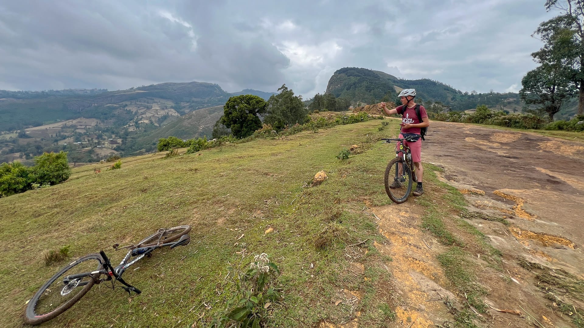 Cyclist riding across open highland terrain with valley views during a cycling trip in Ethiopia