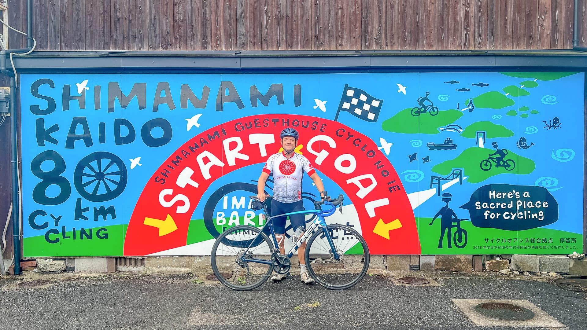 Cyclist posing at the colourful Shimanami Kaido cycling mural in Imabari Japan
