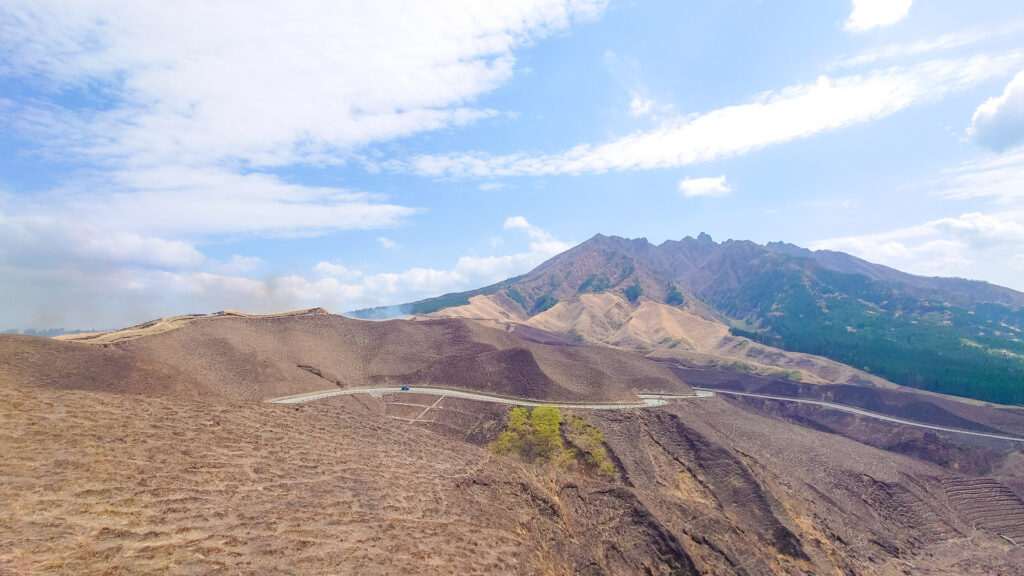 Road winding through volcanic slopes of Mount Aso with wide mountain views in Kyushu Japan