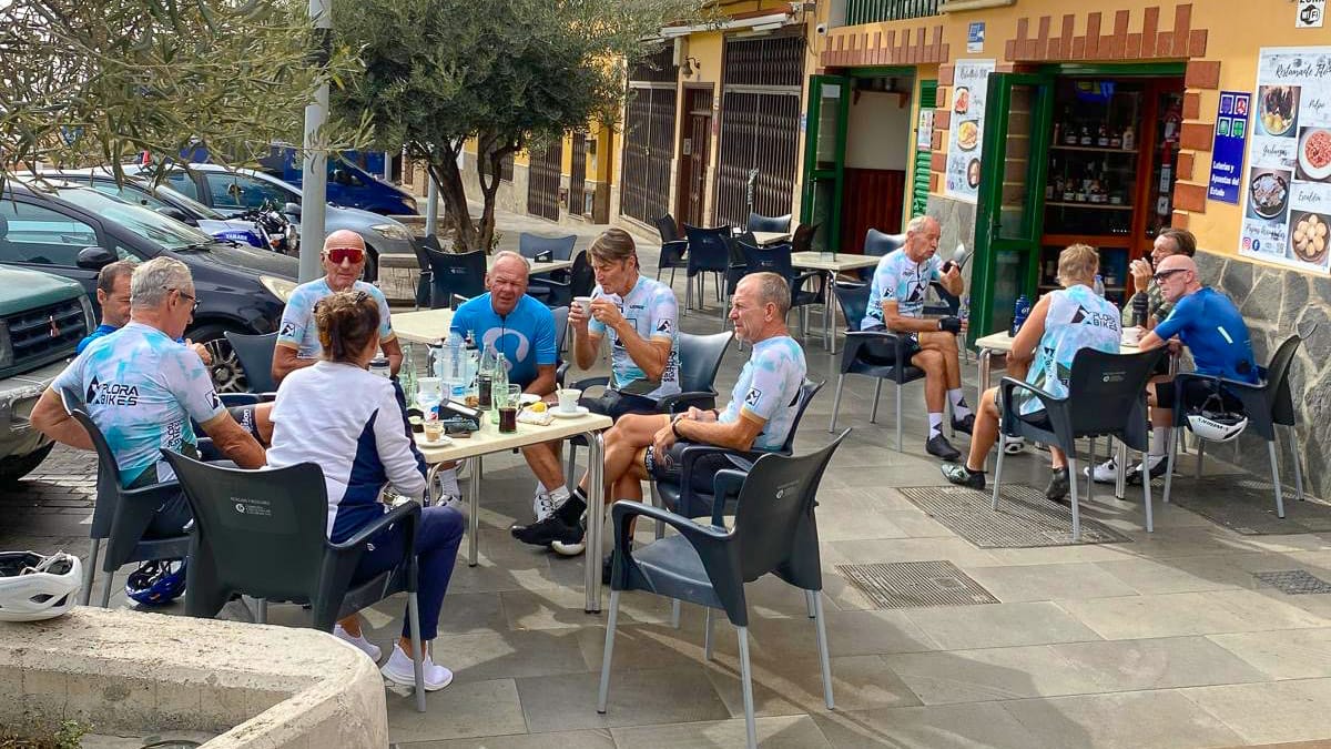 Cycling group relaxing at an outdoor café stop in Tenerife during a ride