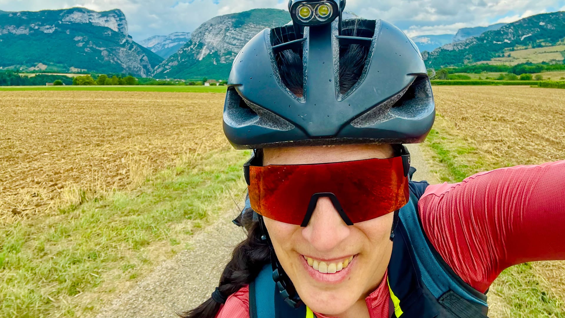 Smiling cyclist taking a selfie with mountain views behind