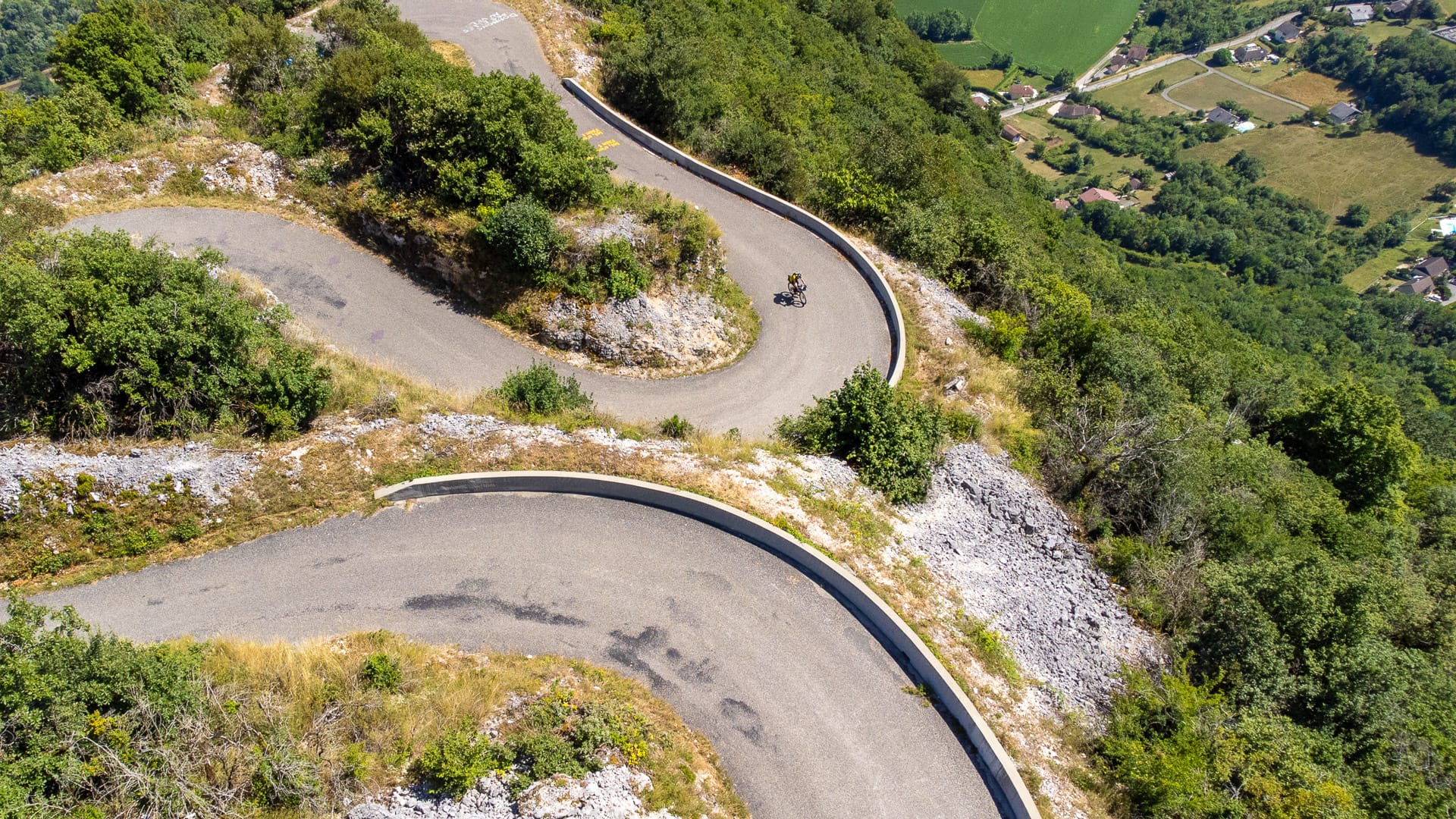 Cyclist descending tight hairpin bends on Tour de France mountain road in France