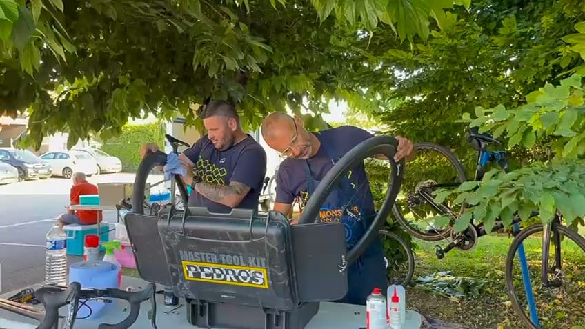 Support crew working on bike wheels in the shade during Tour de France route cycling event in France