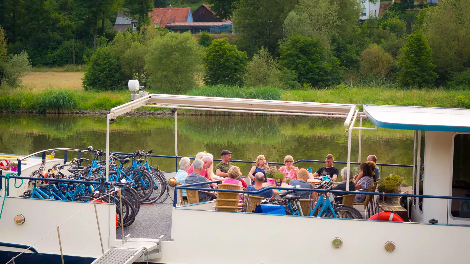 Seniors enjoying a boat and bike tour in Germany along a scenic river route