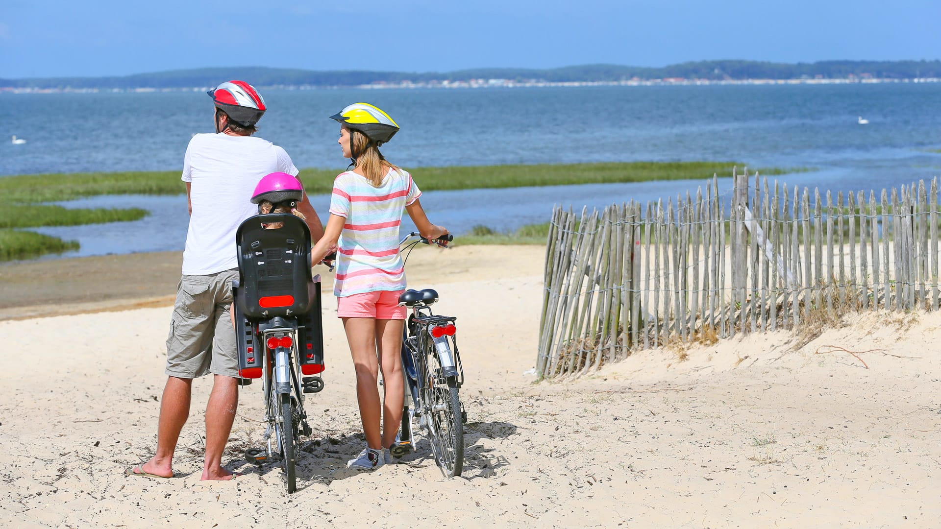 Family on a biking journey making a stop on the beach