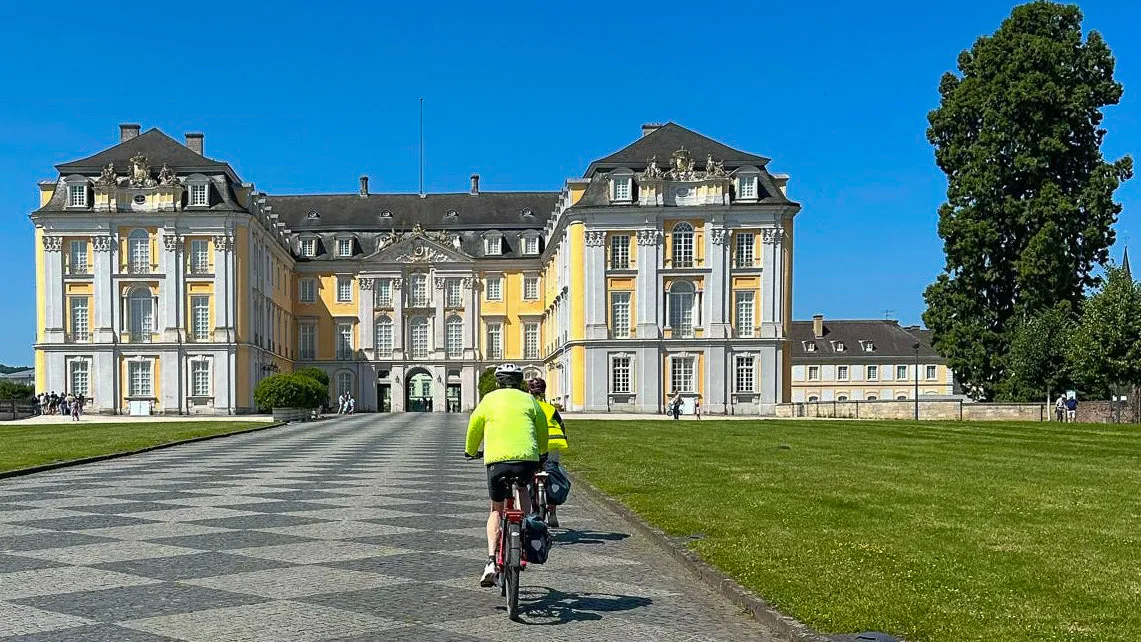 Cycling toward a castle in Brühl, Germany during a tour