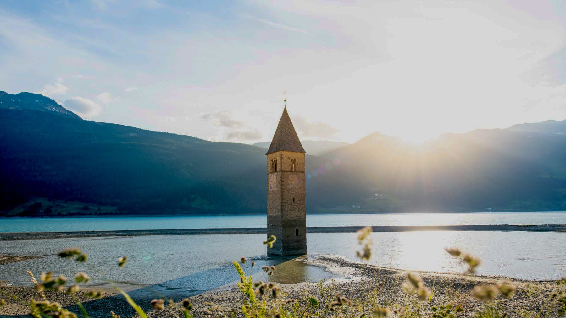 Scenic landscape view around Lake Resia with mountains and open countryside