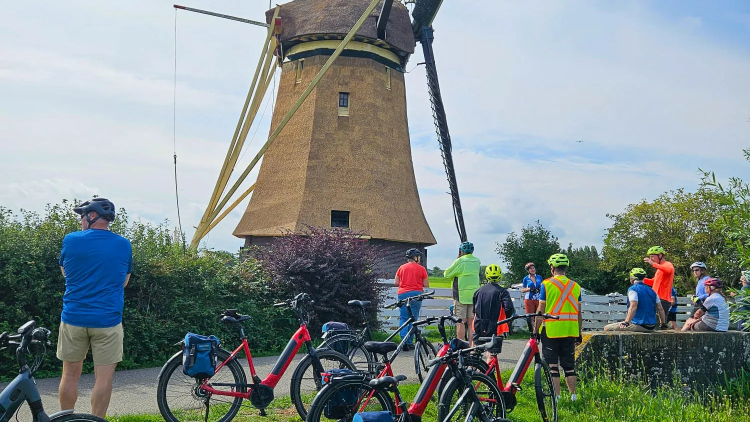 Cyclists stopping to take photos at a windmill with their bikes and bike bags