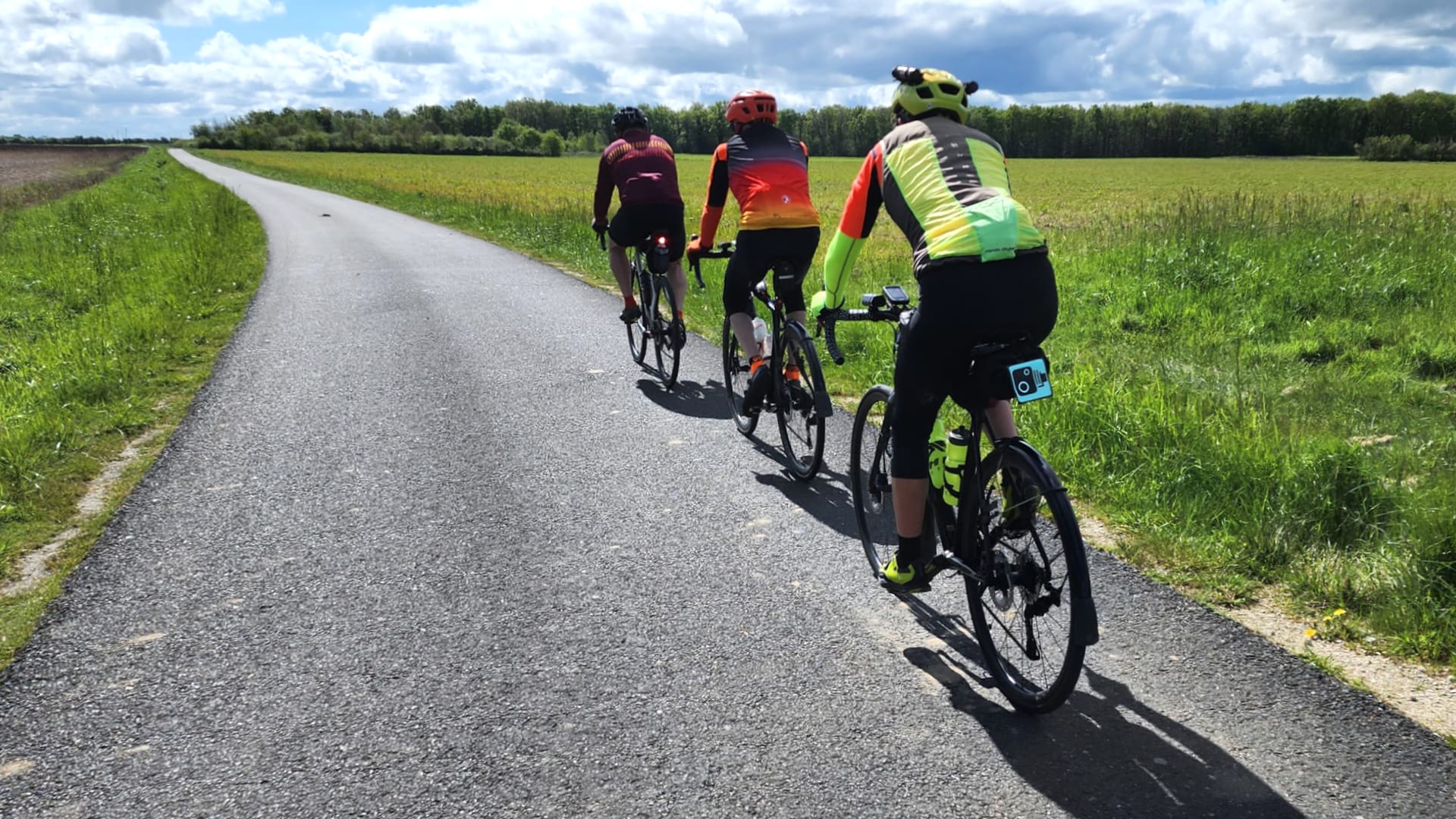 Three cyclists riding a quiet country road on the London to Barcelona cycle route