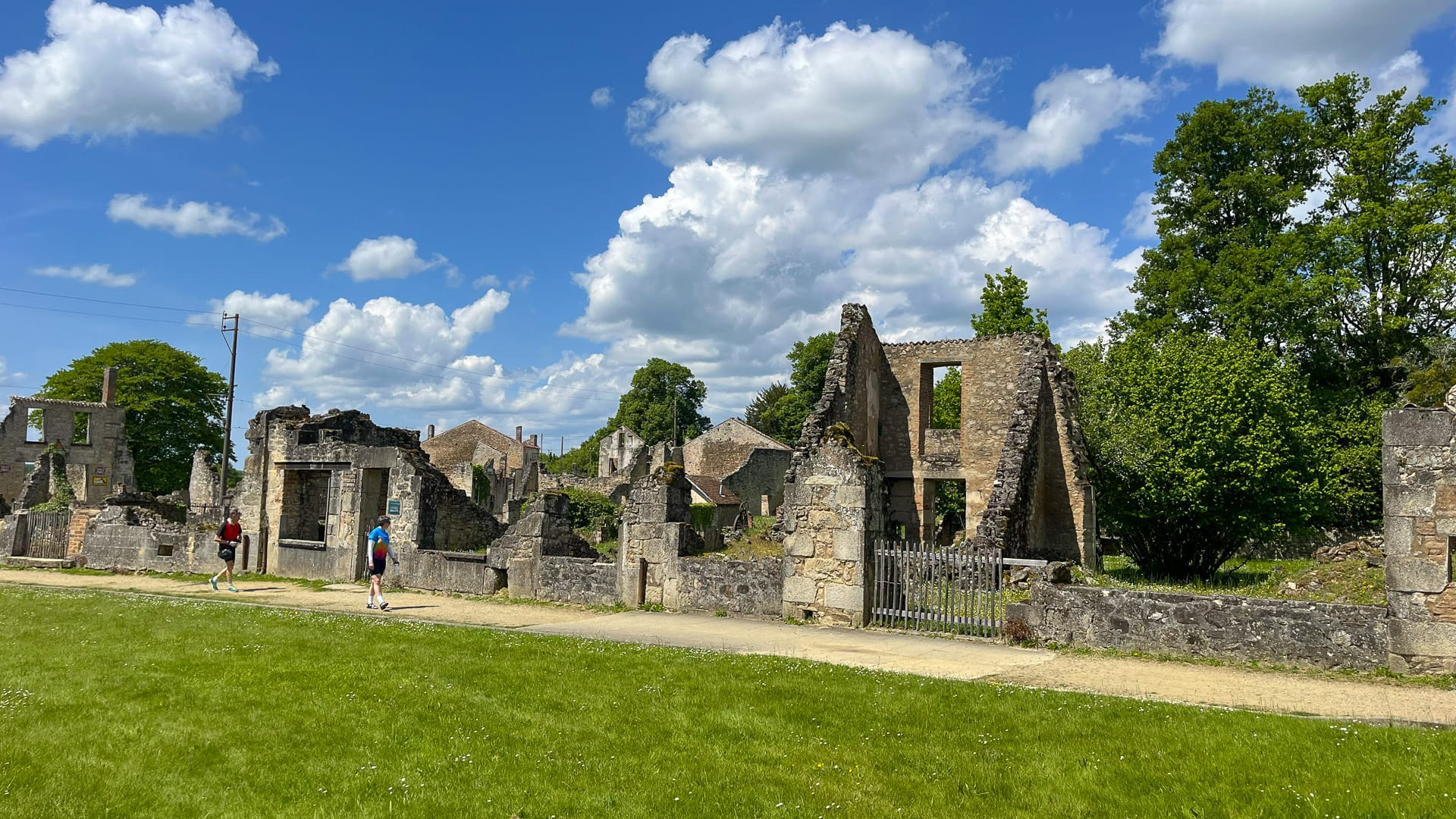 Cyclist exploring Oradour-sur-Glane in France with preserved historic buildings