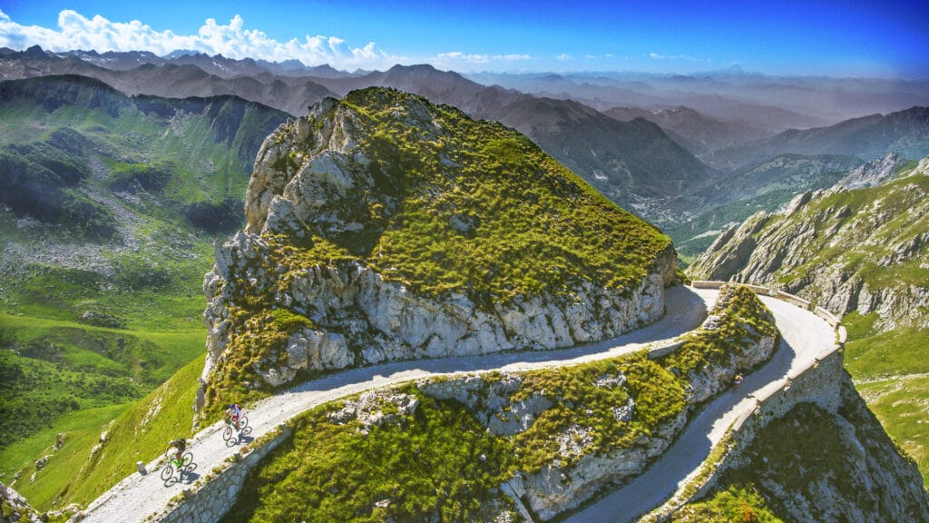Cyclists on Tornante della Boaria with panoramic view on Upper Salt Road