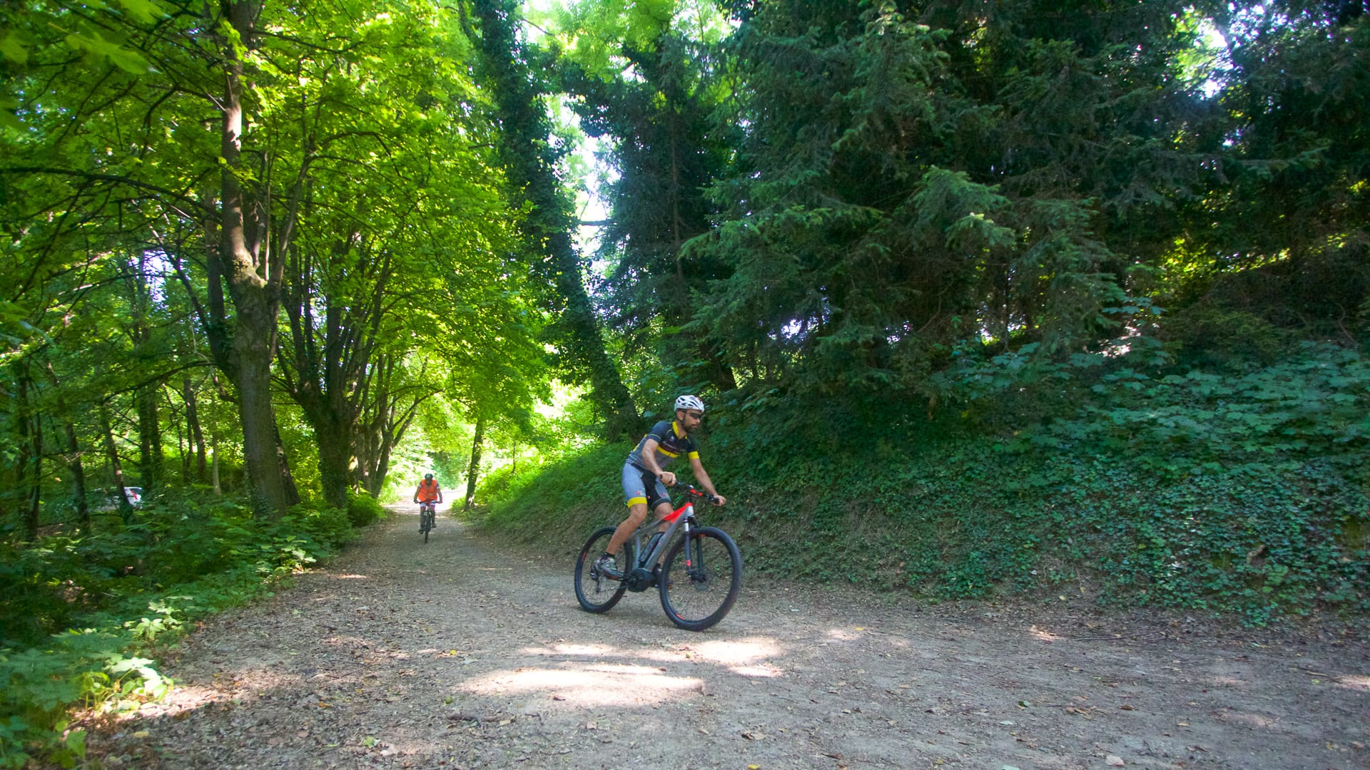 Two cyclists riding along Sentiero Landandè trail in the Italian Alps