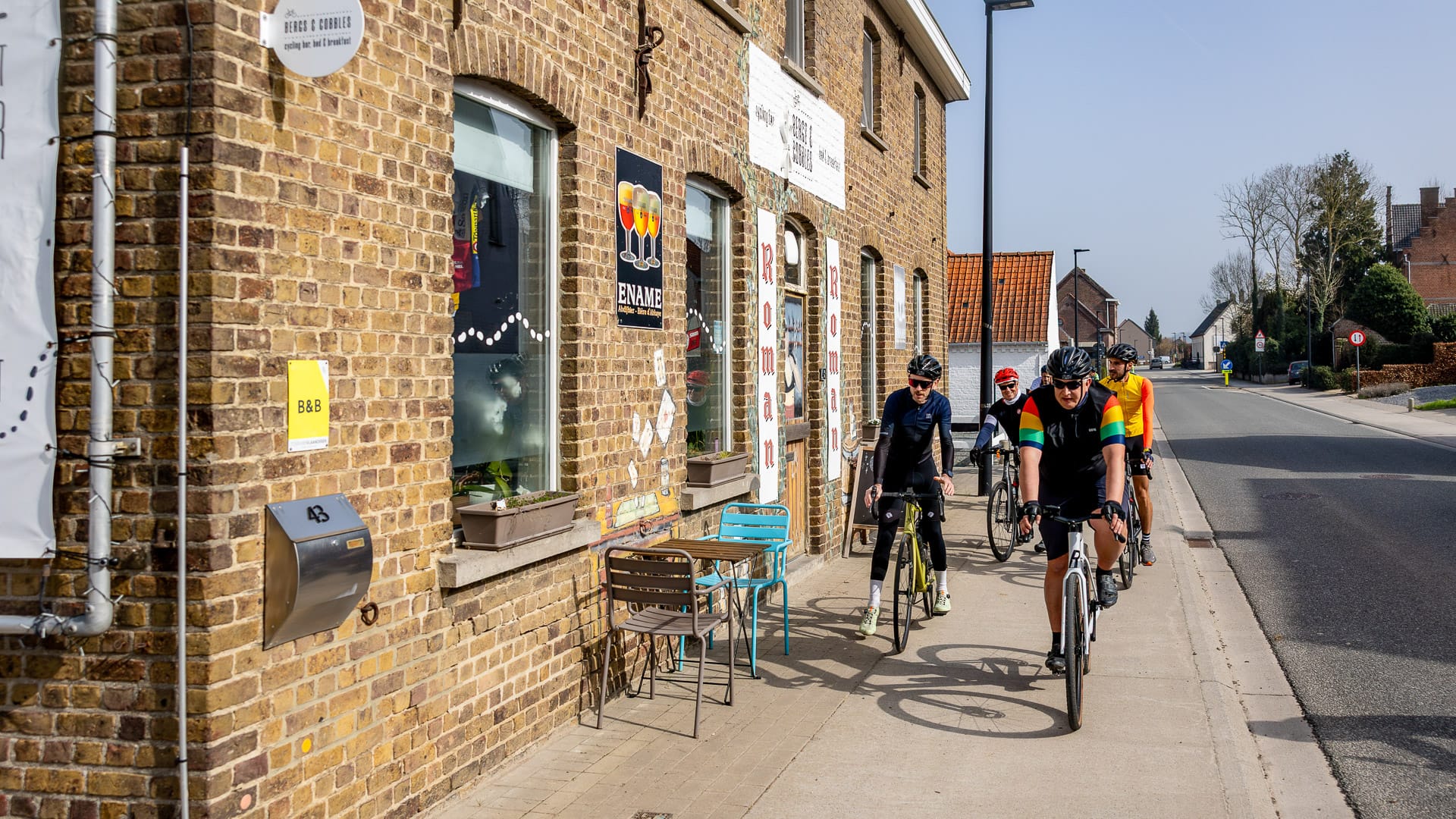 Cyclists ride past popular café stops in Oudenaarde, Flanders, Belgium