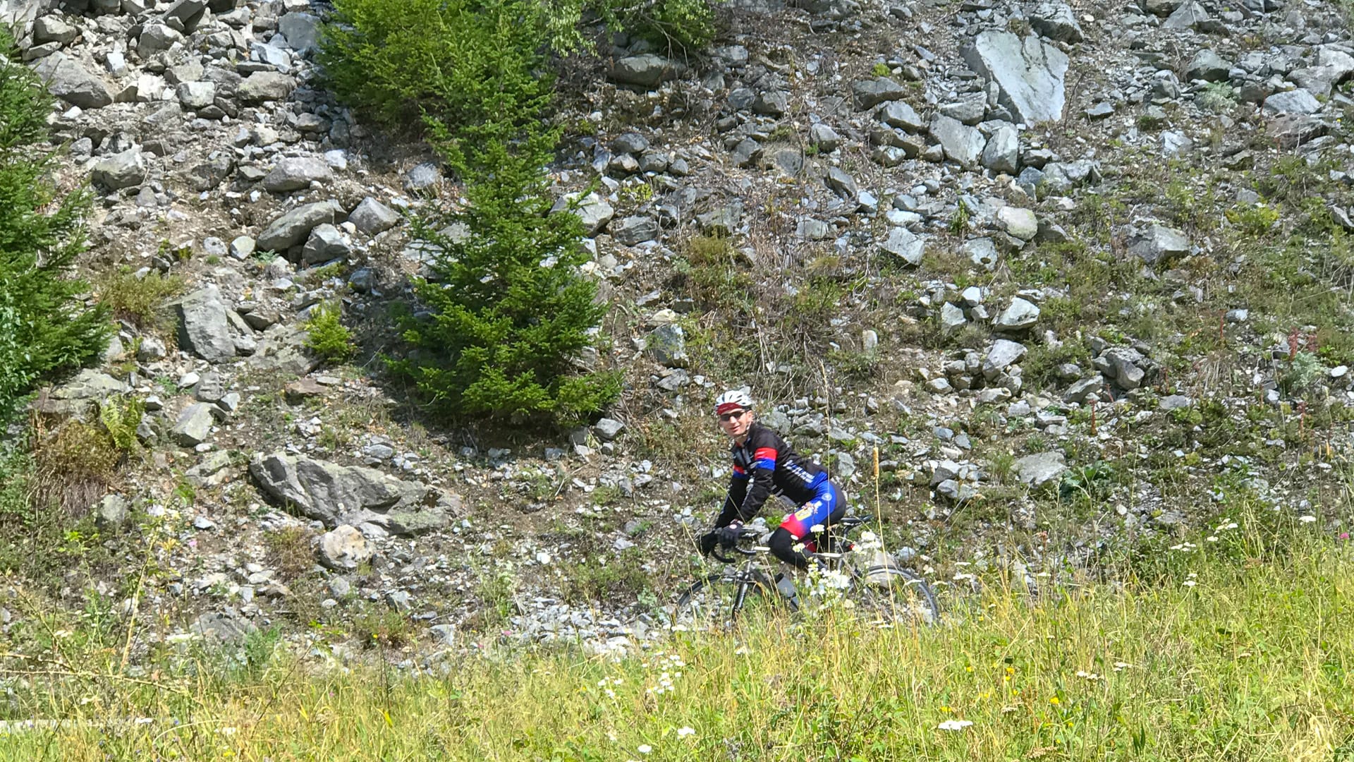 Cyclist riding through Allemond in Isère on quiet alpine roads
