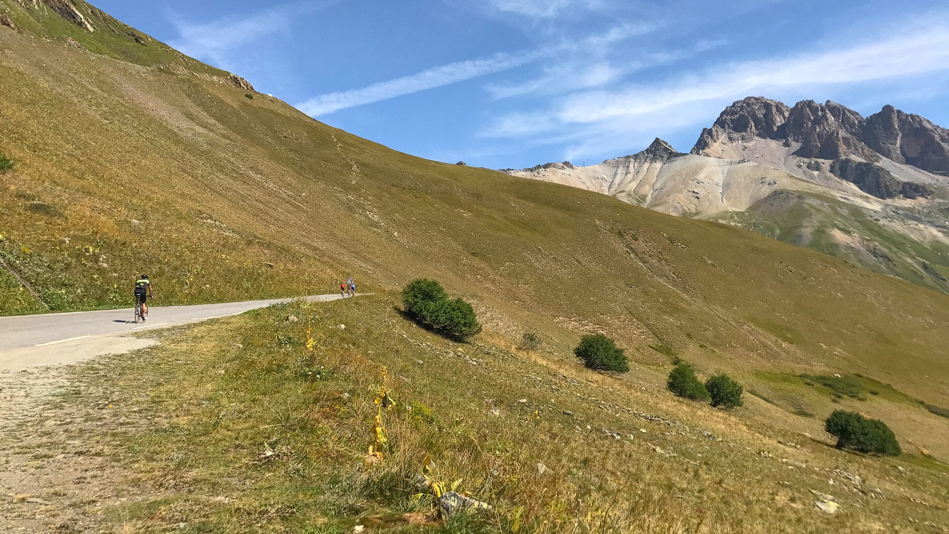 Cyclist climbing Col du Galibier on a high mountain road in the French Alps with open views and steep gradients