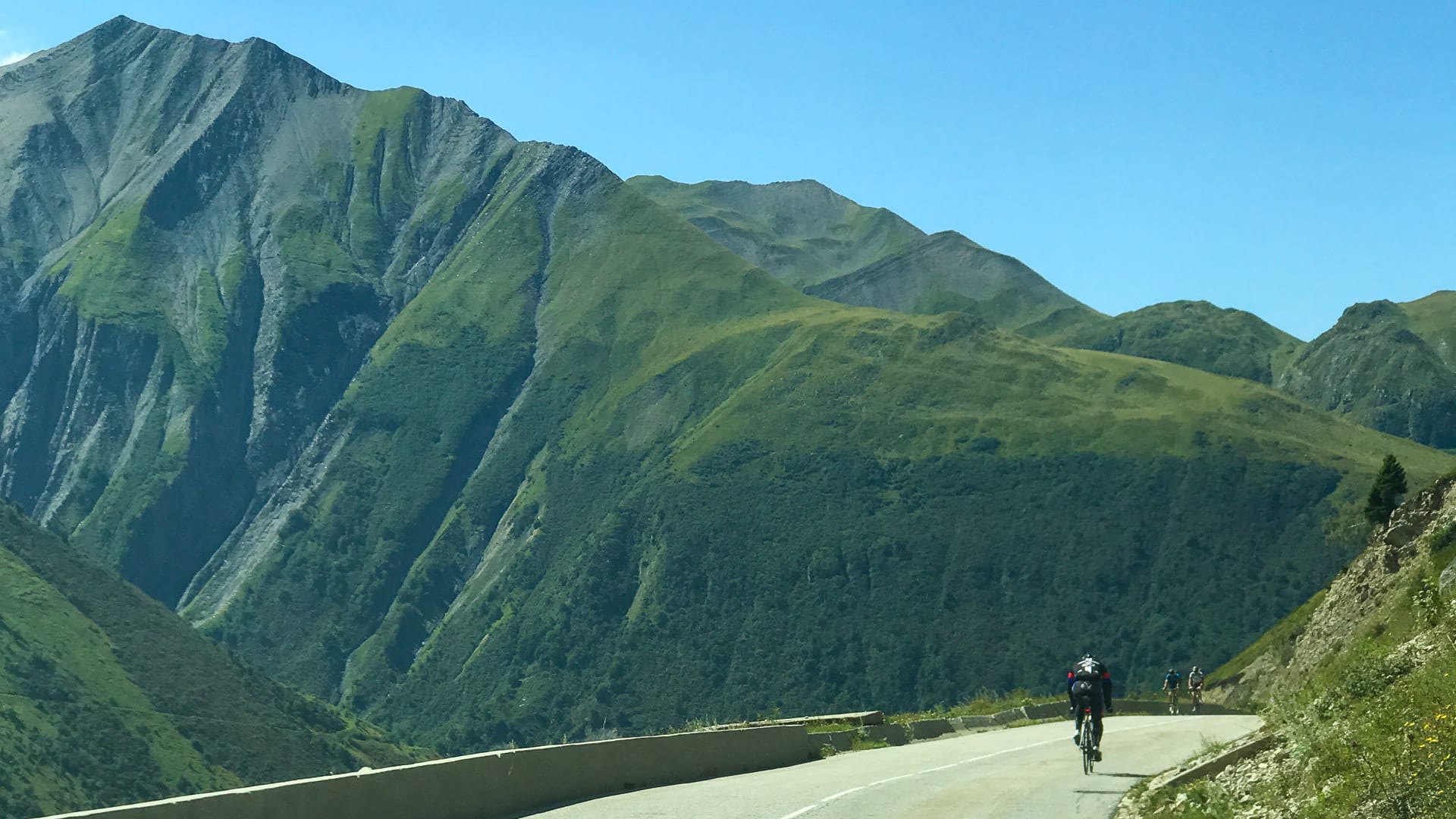Cyclists riding quiet roads in Vaujany, Isère with alpine views and smooth asphalt climbs