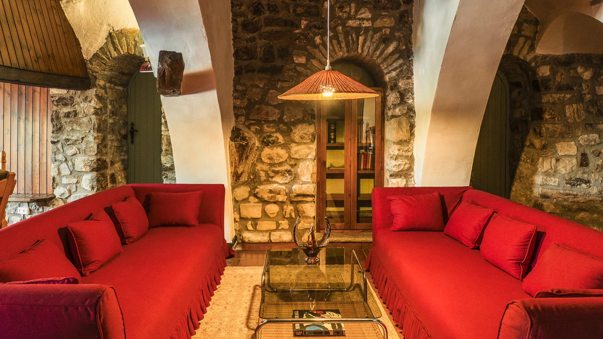 Lounge at Off Grid Girona hotel with red sofa and classic brick wall design