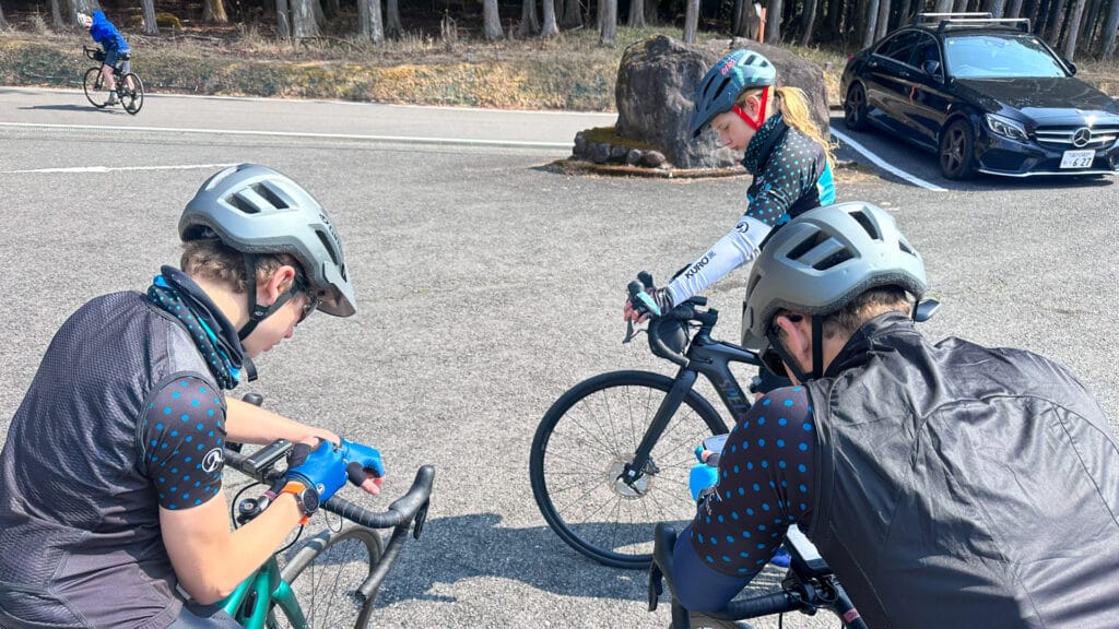 Cyclist checking the Nikko route map on a phone while stopped on the roadside