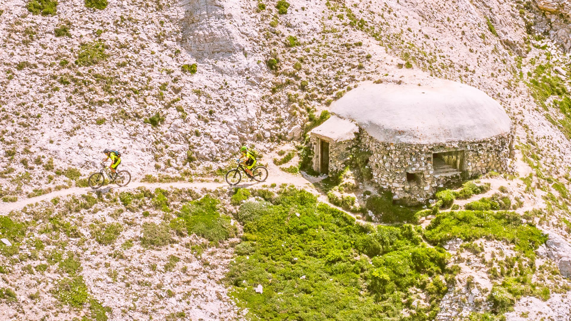 Cyclists passing a WWII bunker on the Gardetta Plateau