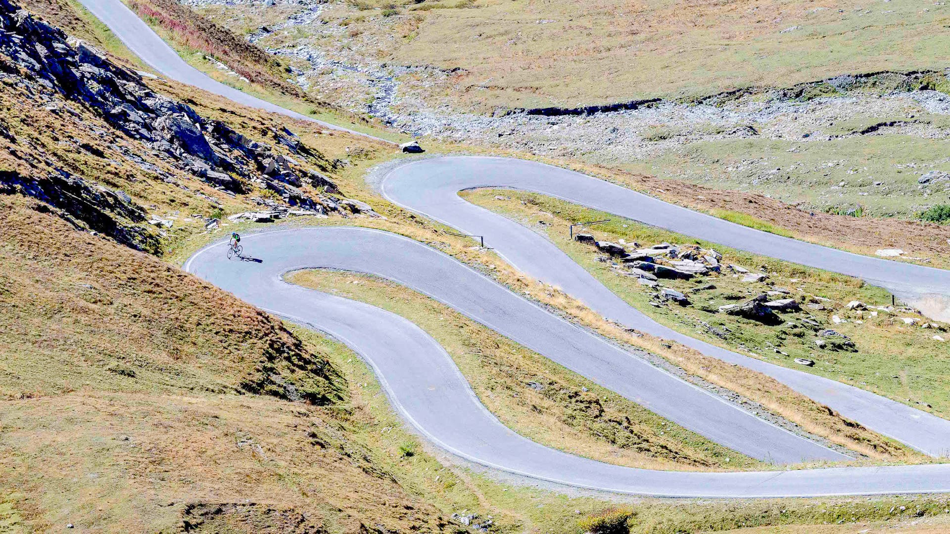 Cyclists climbing up to Agnello Pass in Piedmont