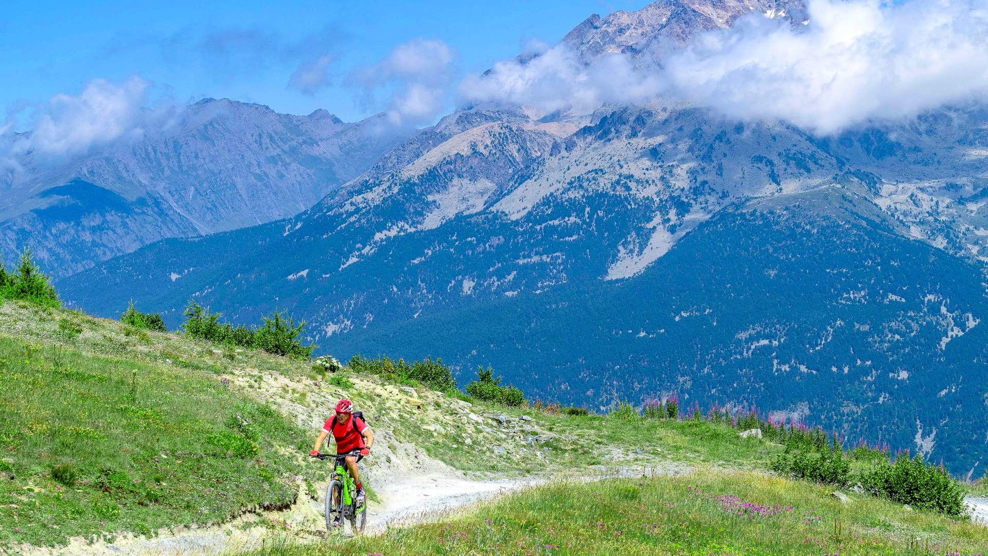 Cyclist on Strada dei Cannoni, with Mount Monviso in the background