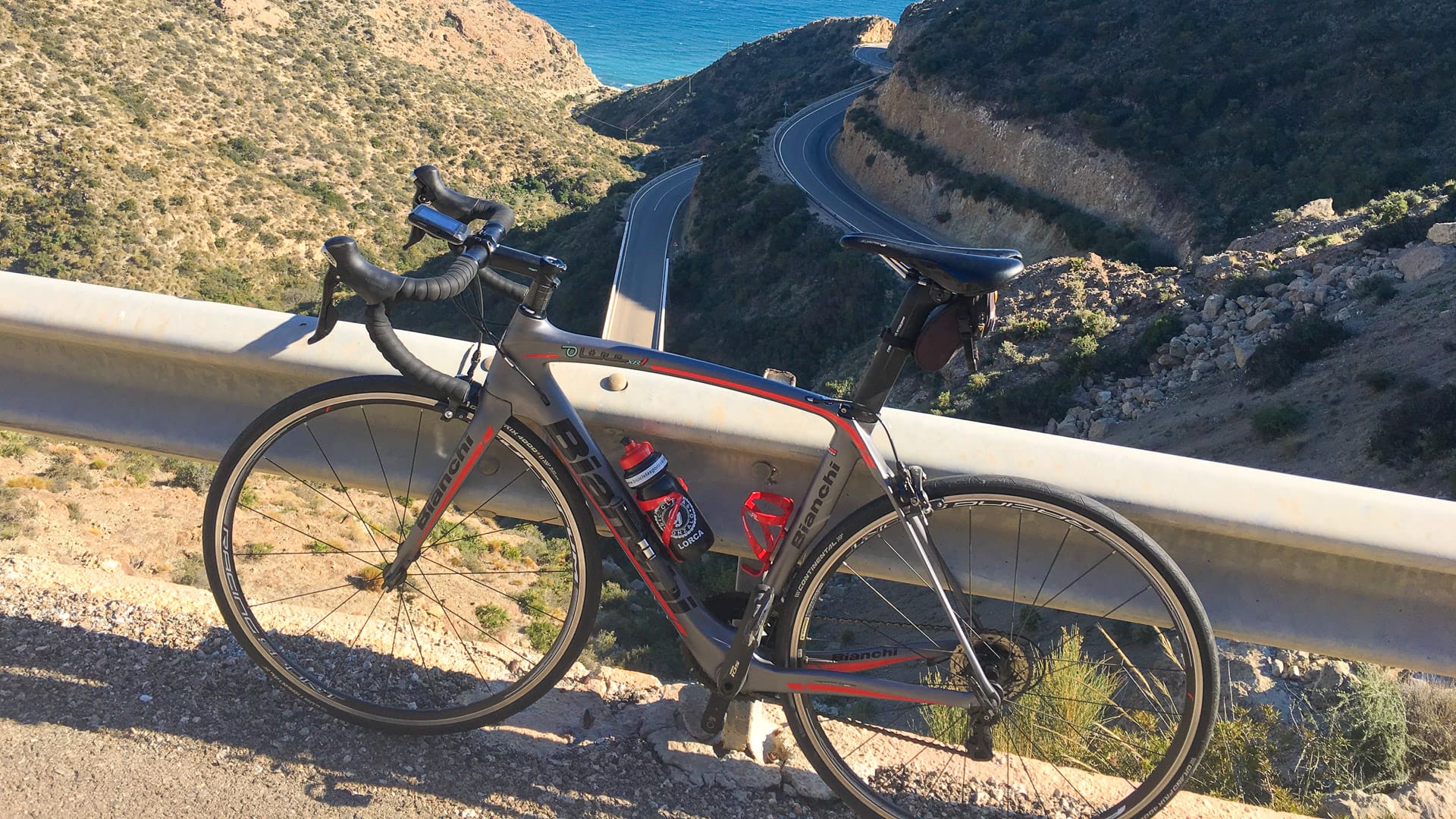 Bike parked above Agua Amarga overlooking winding mountain roads in Almeria, Andalucia