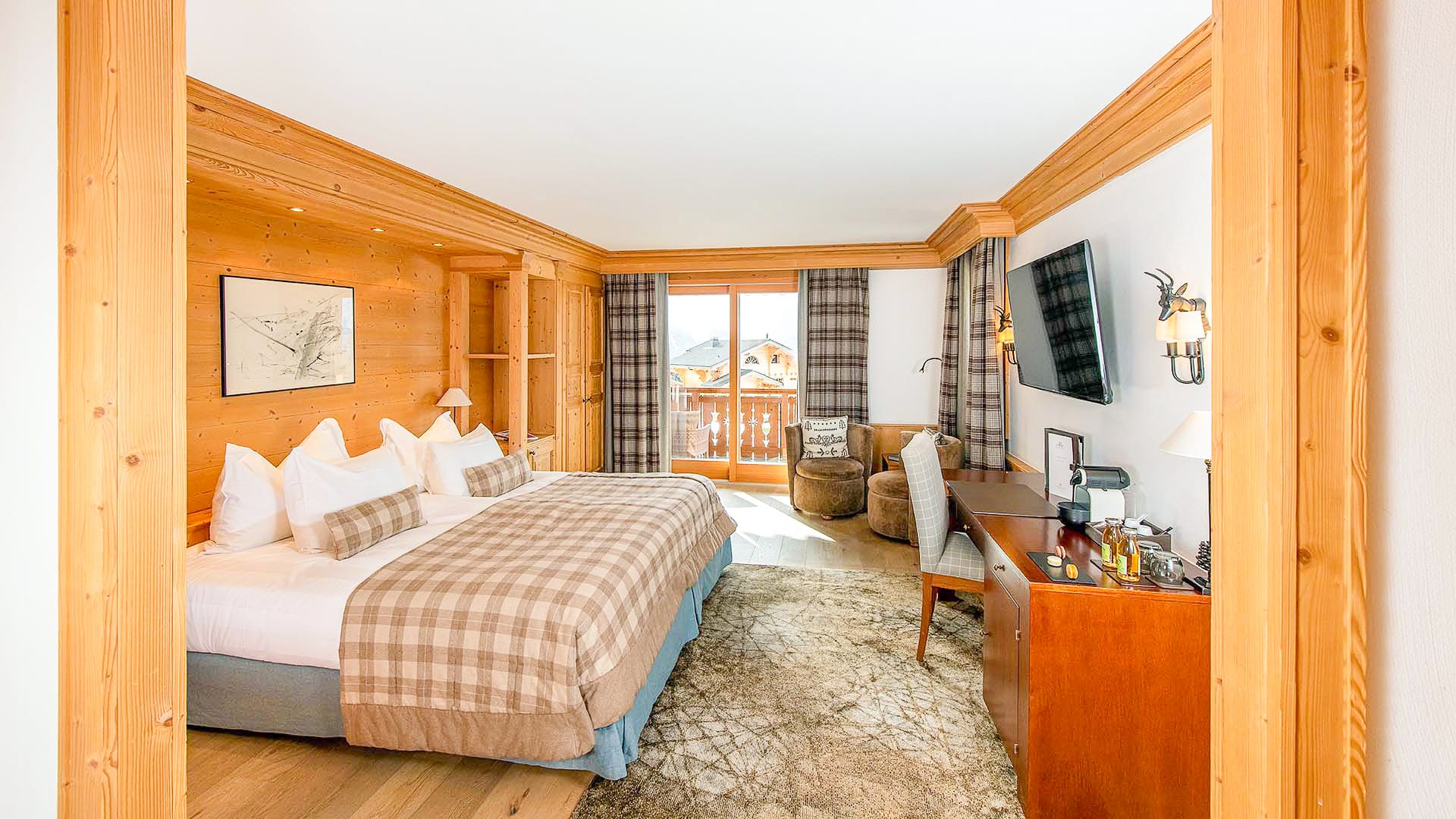 Spacious executive mountain view room at Chalet RoyAlp with warm wooden interiors and panoramic alpine views