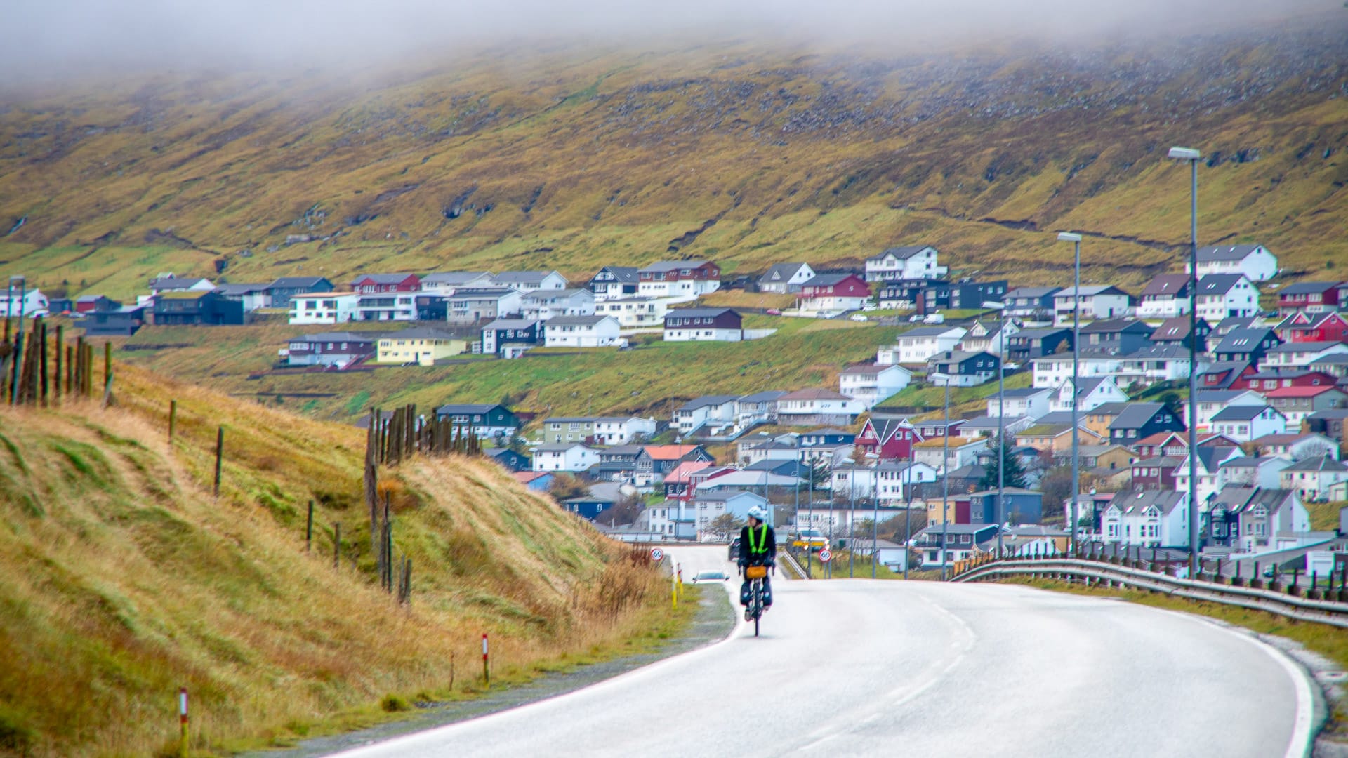 Cyclist riding out of Klaksvík village
