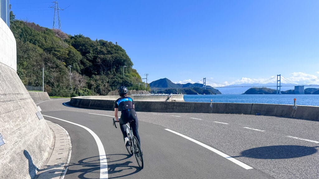 Cyclists riding on Oshima Island in Japan on day two with coastal sea views