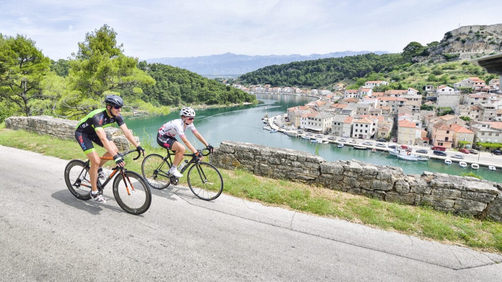Cyclists passing by Novigrad, a well-known fishing village