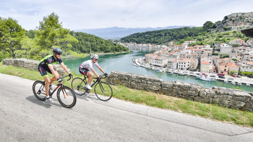 Cyclists passing by Novigrad, a well-known fishing village