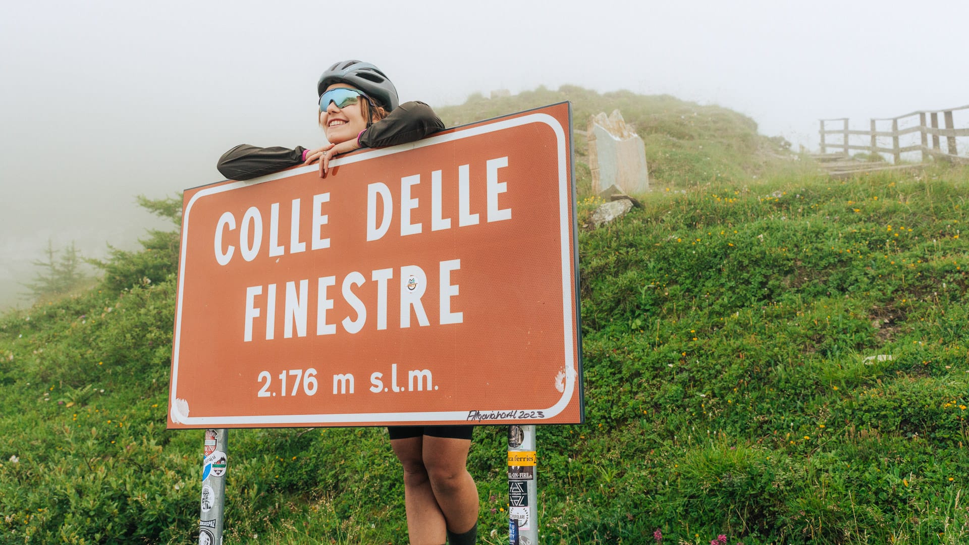 Cyclist posing beside the Colle delle Finestre sign in Piemonte