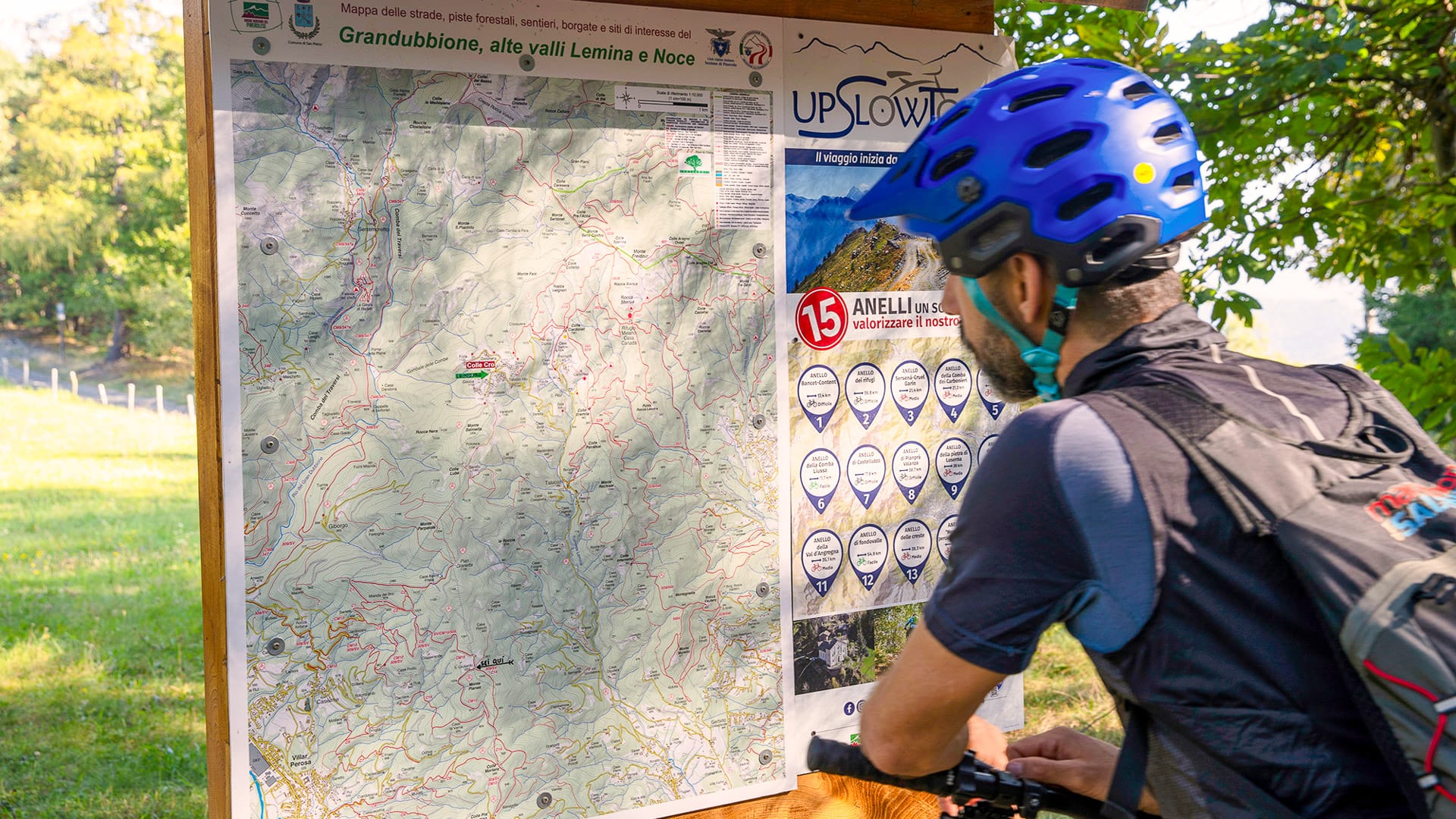 Cyclist checking a route map in Val Pellice