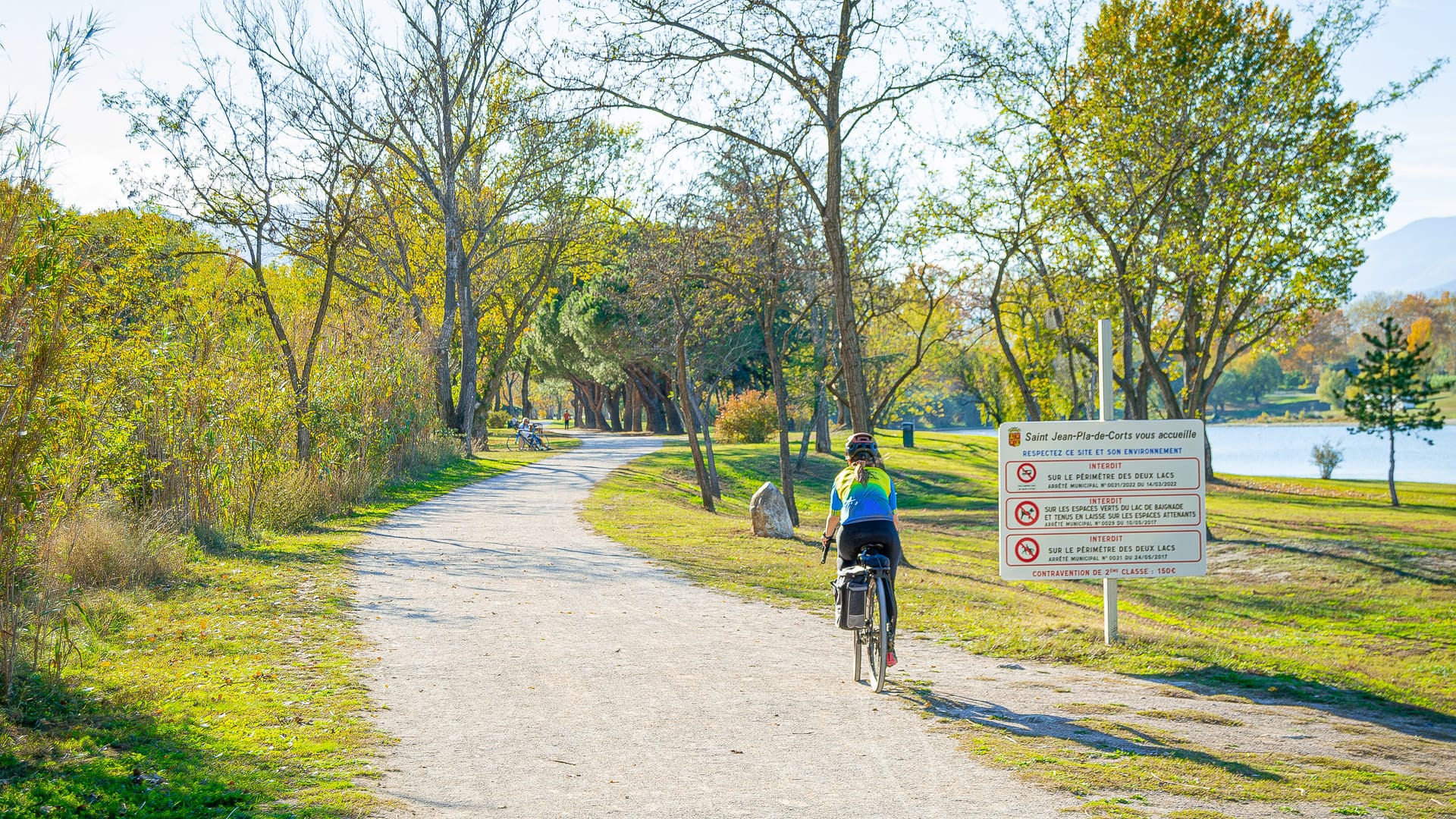 Cyclist following a Pirinexus signpost in Saint-Jean-Pla-de-Corts