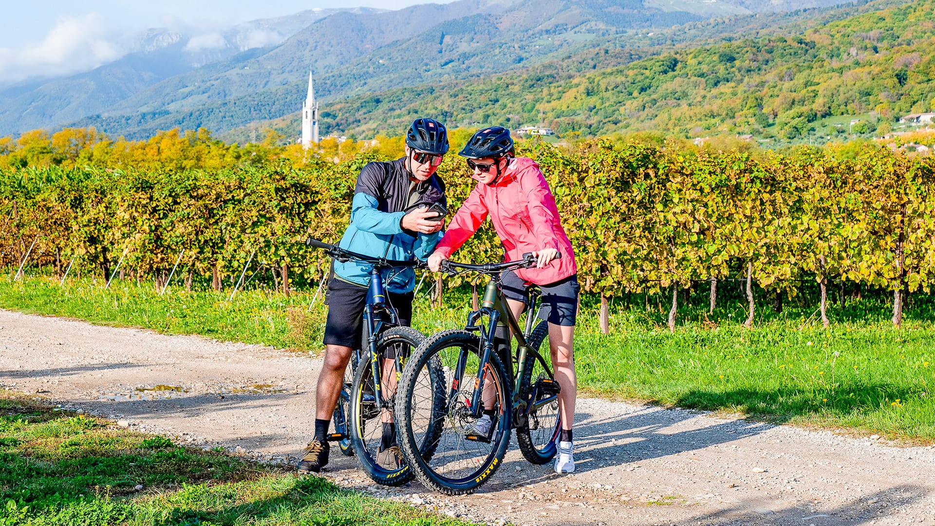 Cyclist checking a route map while riding in the Prosecco Hills, Italy