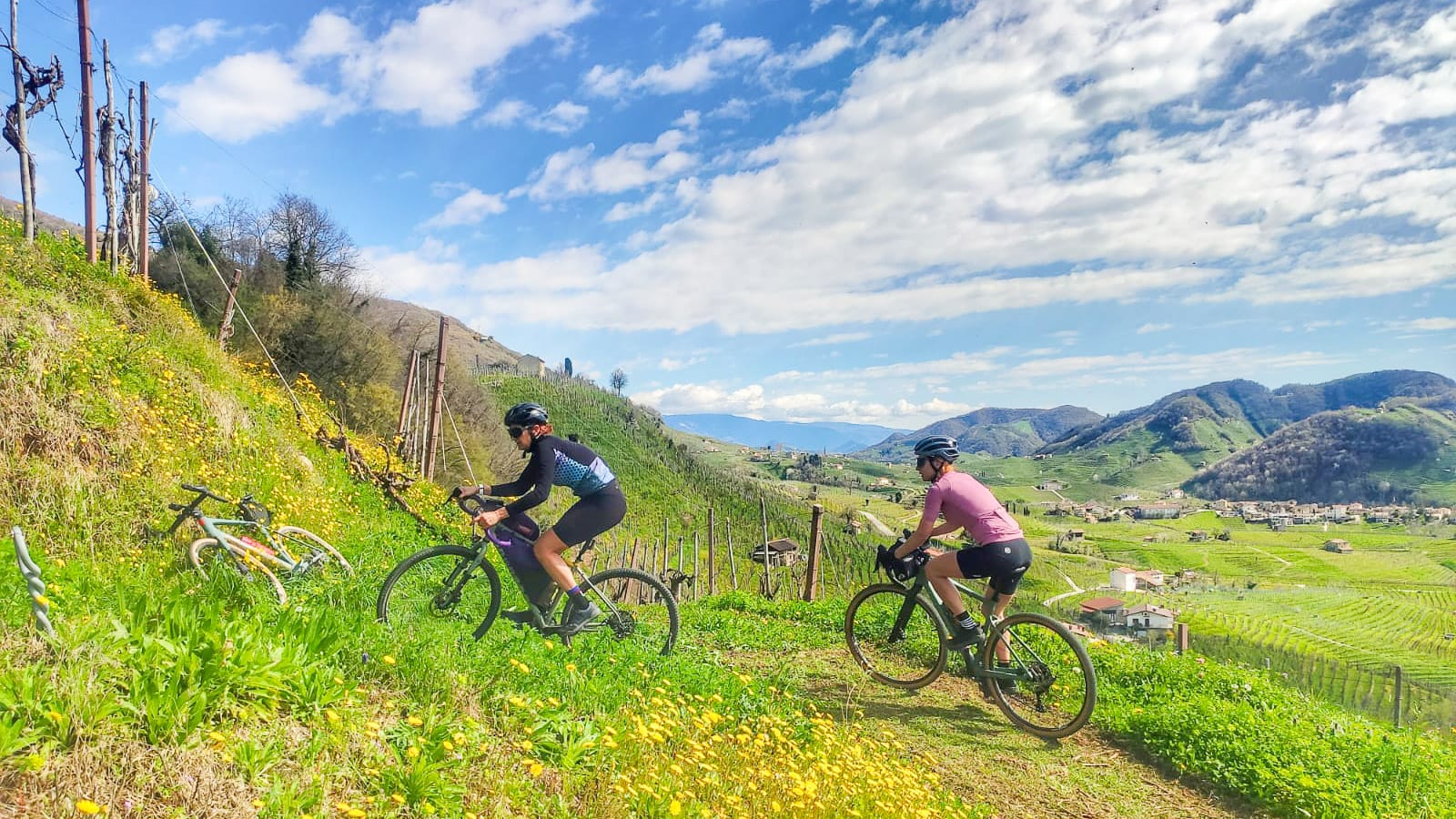 Gravel cyclist descending through Prosecco vineyards in the UNESCO-listed hills of Veneto, Italy