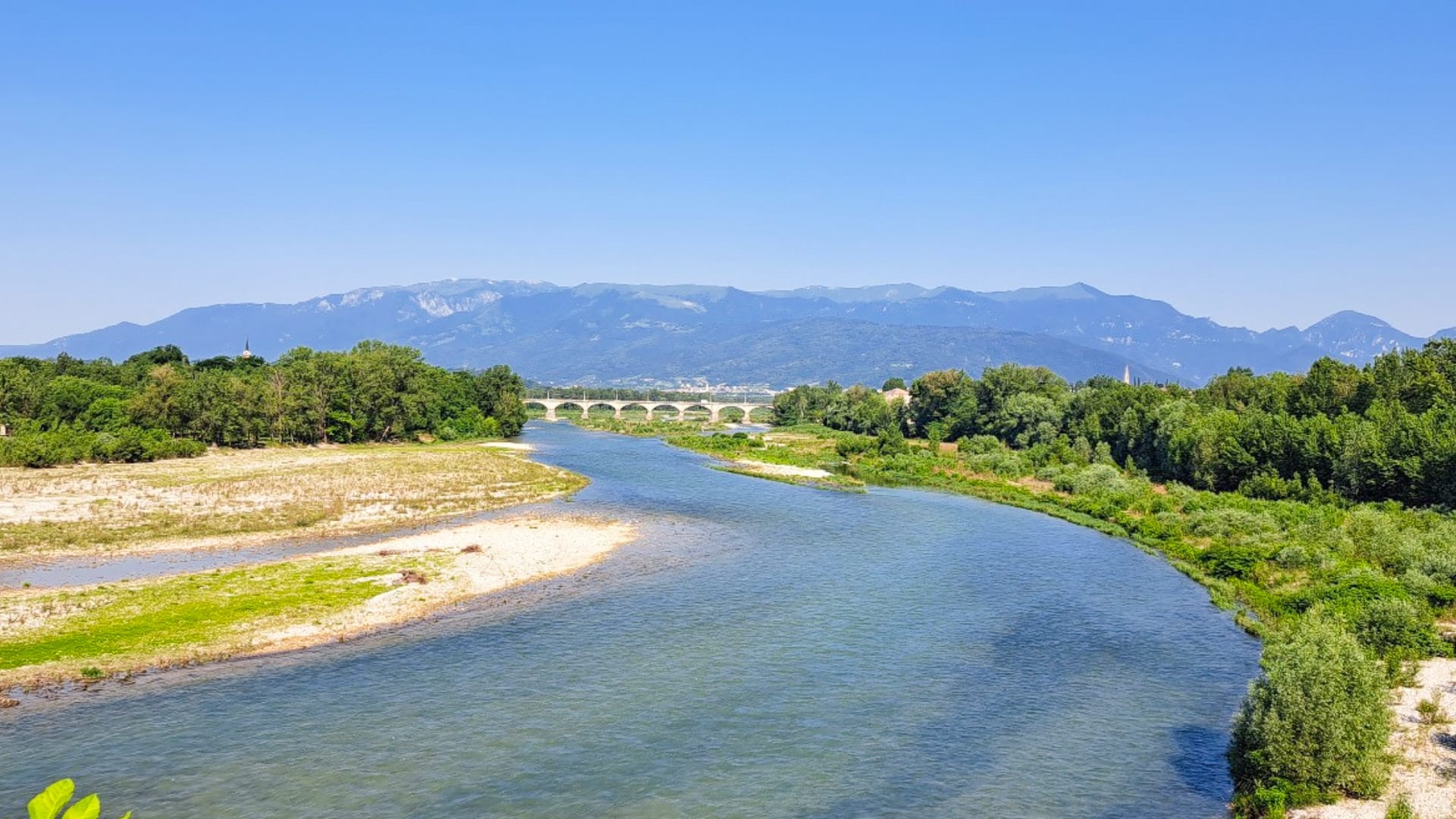 Cyclist riding alongside the Piave River between the Prosecco Hills and Colli Asolani