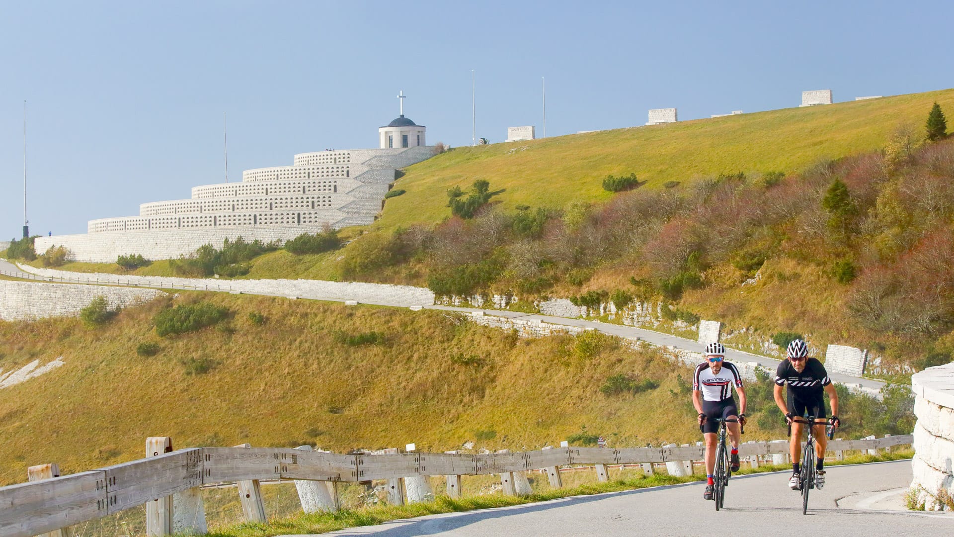 Road cyclists climbing towards the Sacrario of Monte Grappa in Veneto, Italy