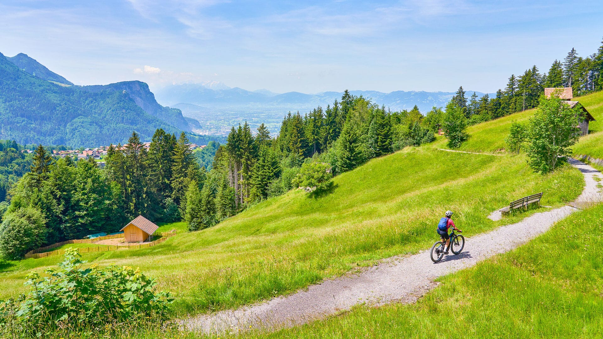 Woman riding a bike in the Bregenzerwald mountains above Dornbirn and the Rhein Valley, Vorarlberg, Austria