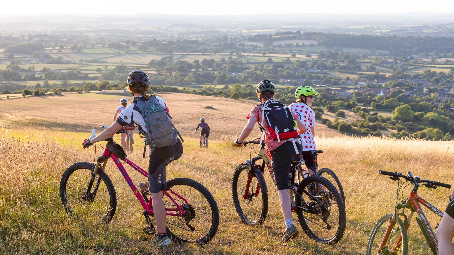 Cyclists admiring the view from a hilltop viewpoint in Dorset
