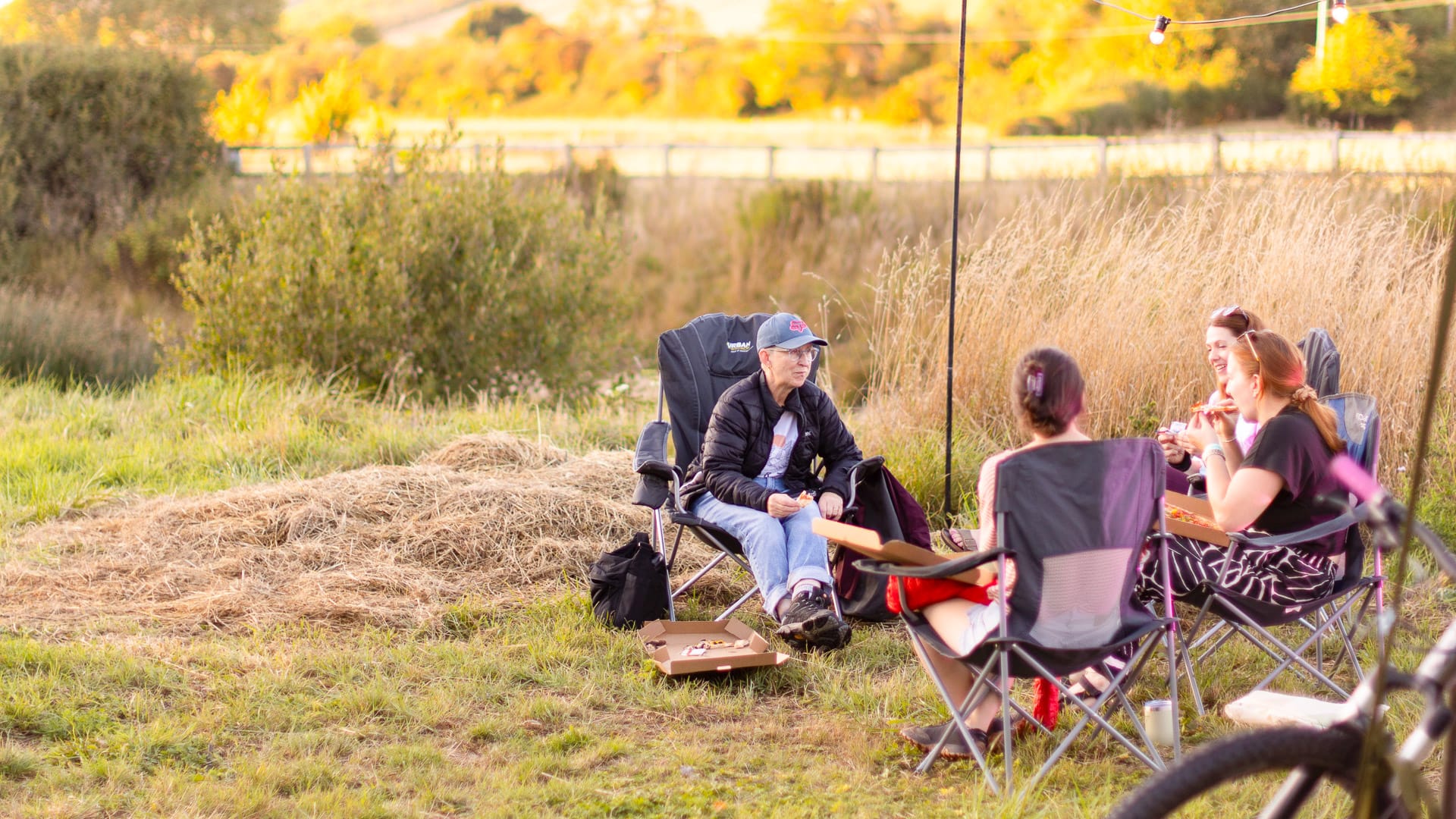 Girls sitting on camping chairs together at a camping area in Dorset