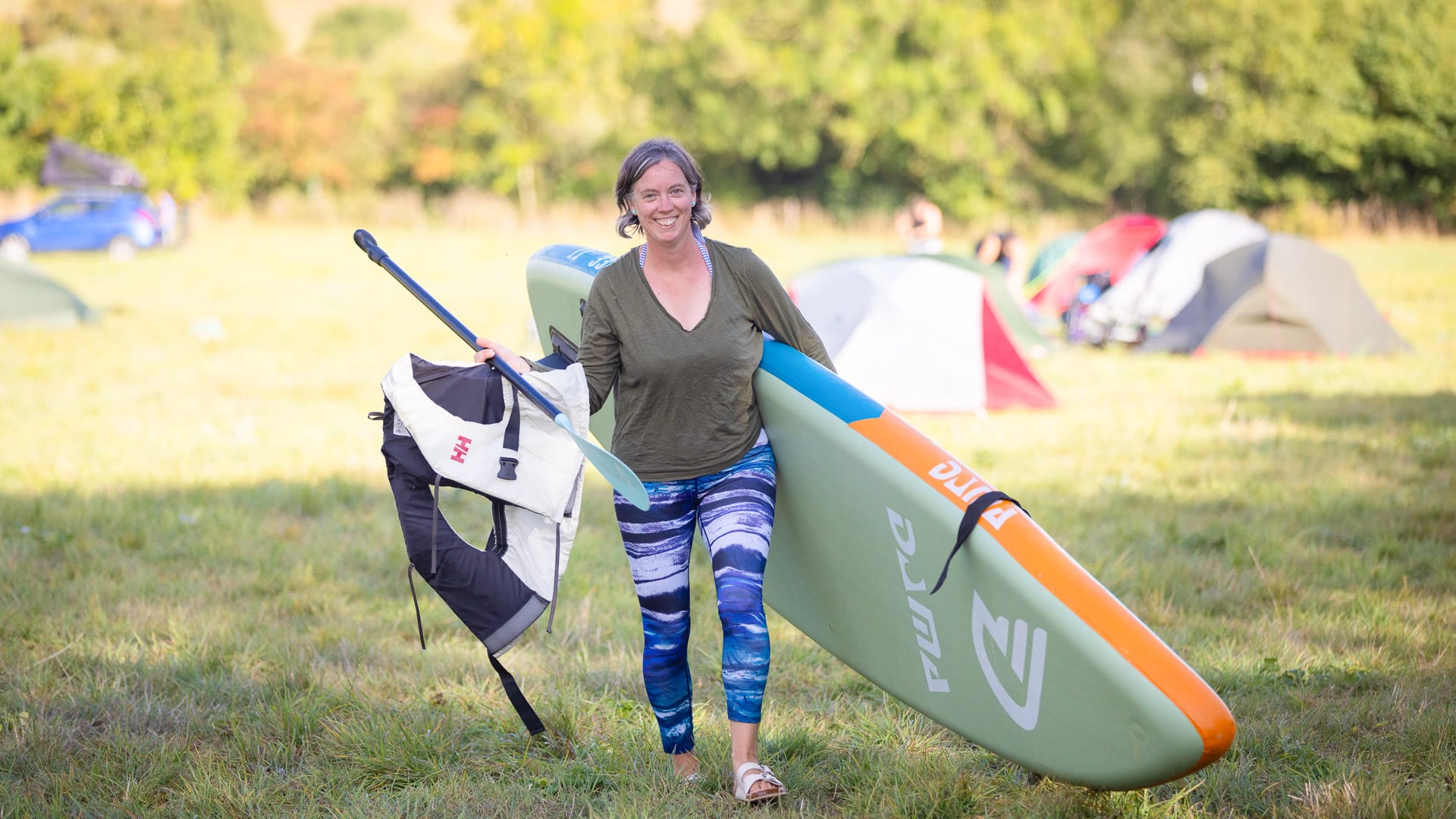 Girl holding paddleboarding equipment during a Dorset activity