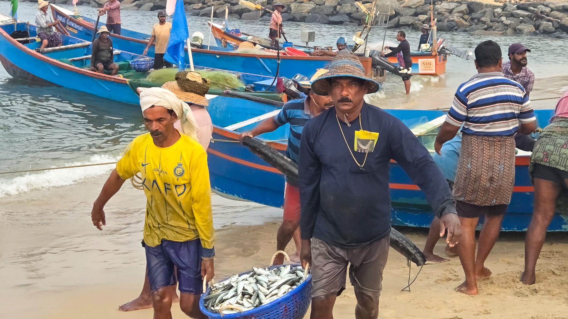 Fishermen returning at sunrise as the fresh catch is sorted on the beach