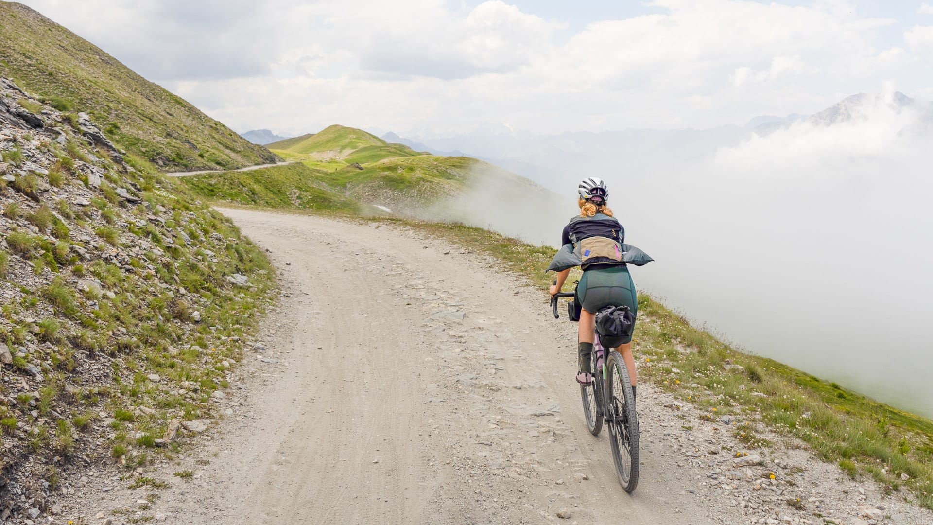 Woman cyclist climbing a mountain route in Piemonte