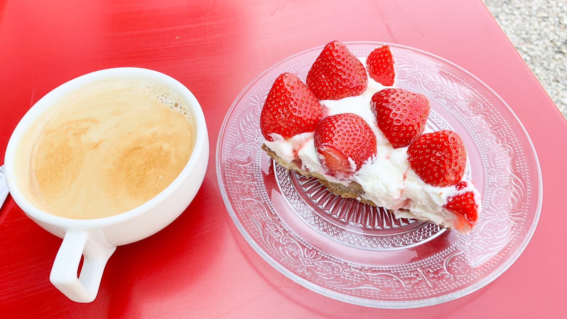 Slice of strawberry cake served with a cup of coffee